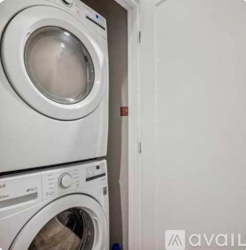 Two white front loading washing machines in a small room.