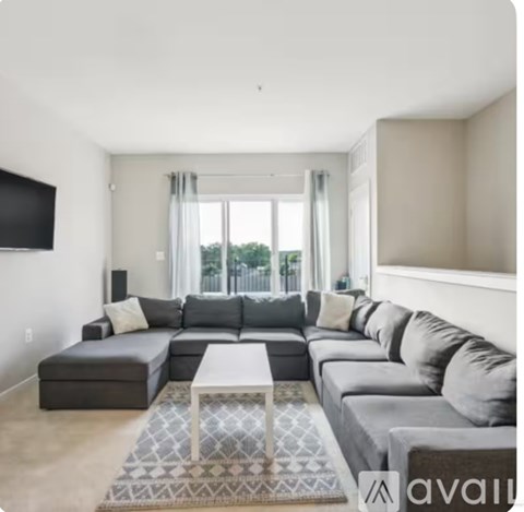 A living room with a grey sectional sofa and a white coffee table.