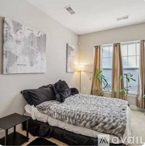 A bedroom with a large bed and a map on the wall.