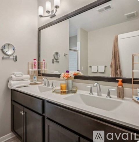 A bathroom with a large mirror above a double sink vanity.