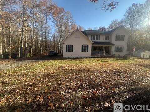 A house with a lawn covered in fallen leaves.