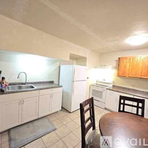A kitchen with white appliances and wooden cabinets.