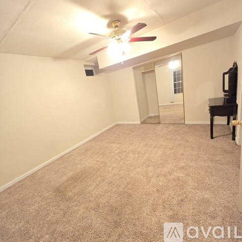 A room with a ceiling fan and a carpeted floor.