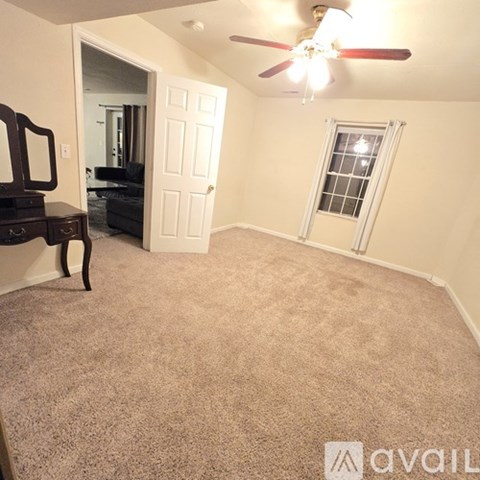 A room with a ceiling fan and a window.