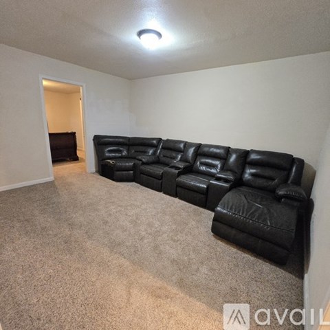 A black leather sectional sofa in a living room.