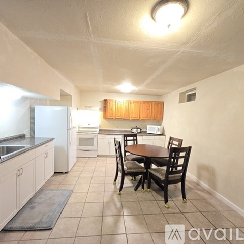 A kitchen with a table and chairs in the middle of the room.