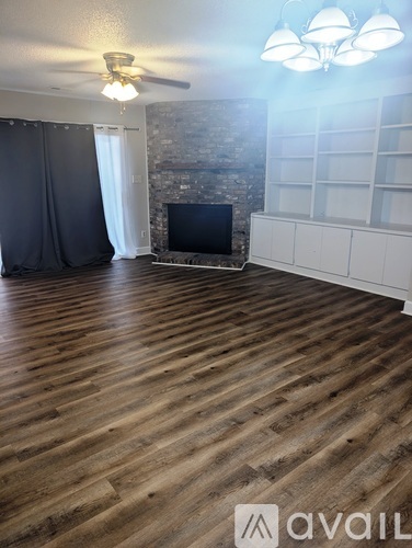 A living room with a fireplace and wooden floors.