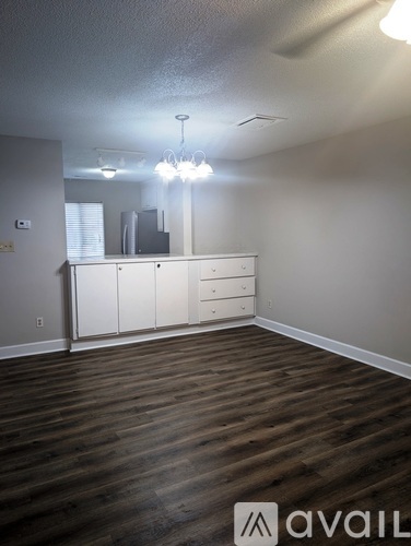 A room with wooden floors and a chandelier.