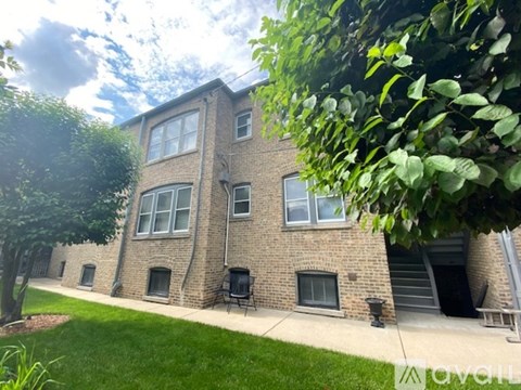 A brick building with a tree in front of it.