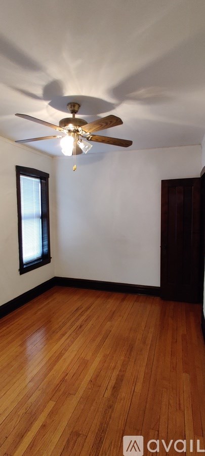 A room with wooden floors and a ceiling fan.
