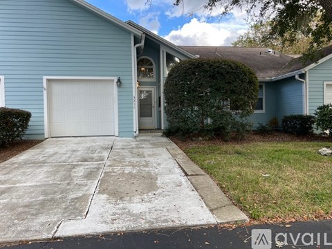 A blue house with a white garage door and a driveway.