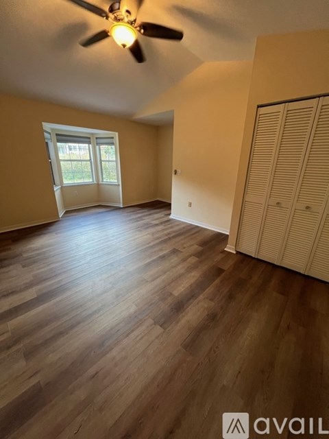 A room with wooden flooring and a ceiling fan.