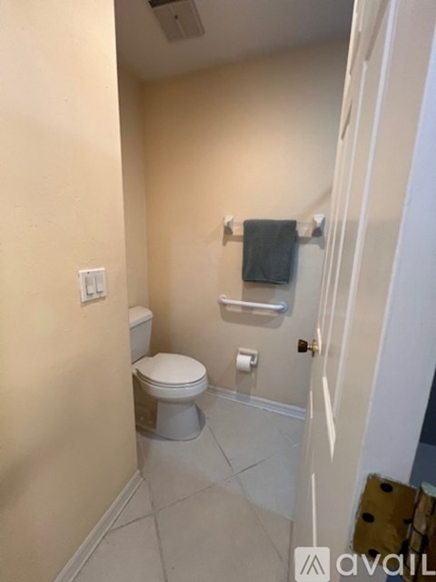 A bathroom with a toilet and a towel rack.