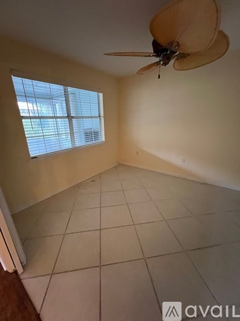 A room with a ceiling fan and a window.