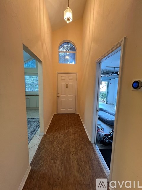 A hallway with a door at the end and a window above it.