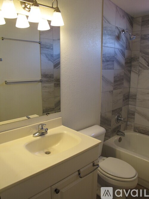 A bathroom with a sink, toilet and a mirror.