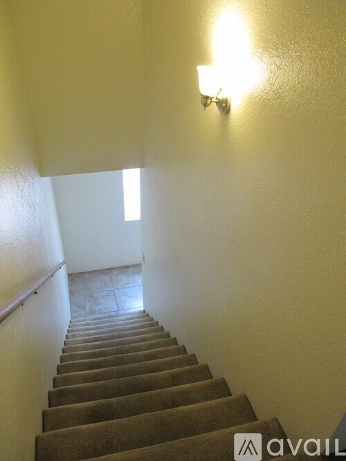 A staircase with a light on the wall.