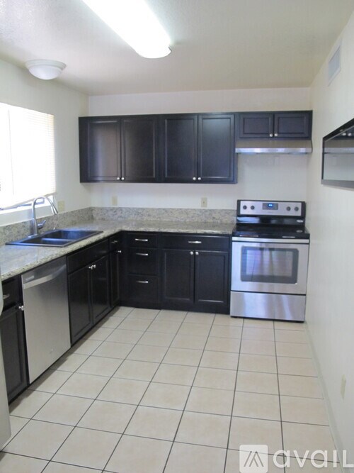 A kitchen with black cabinets and white appliances.