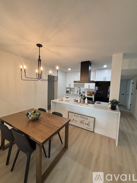 A modern kitchen with a wooden dining table and chairs.
