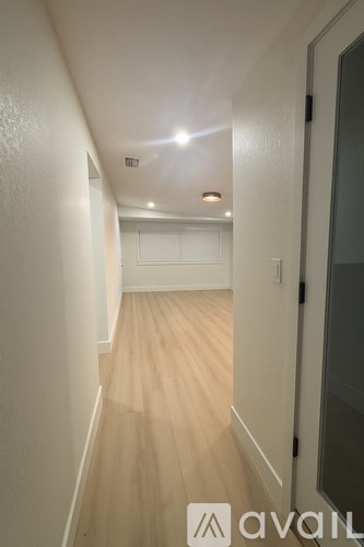 A hallway with wooden floors and white walls.