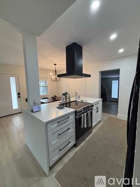 A modern kitchen with a large island and stainless steel appliances.