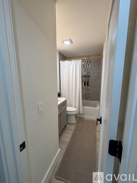 A bathroom with a toilet, sink, and shower.