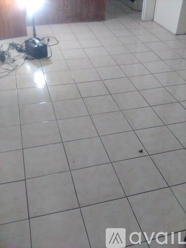 A robot is on a white tiled floor.