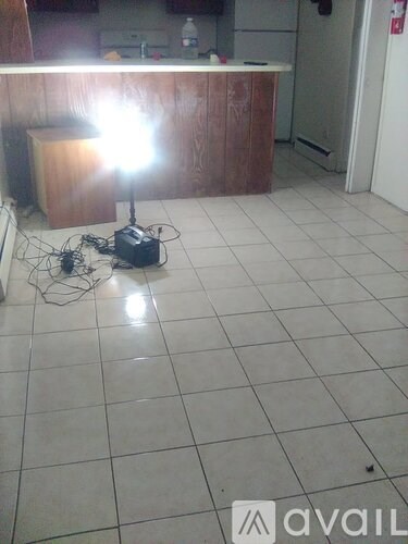 A room with a white tiled floor and a wooden cabinet.