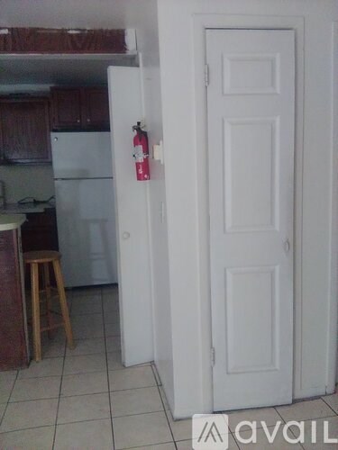 A white door with a red fire extinguisher on the side.