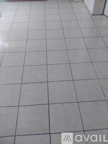 A white tiled floor with a logo in the bottom right corner.