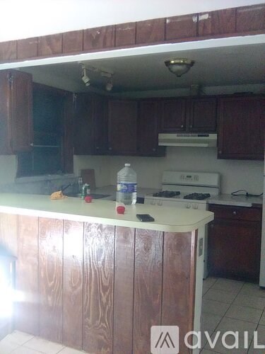 A kitchen with wooden cabinets and a white counter.