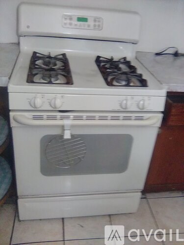 A white gas stove with two burners and an oven is in a kitchen.