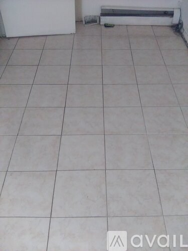 A room with a white tile floor and a radiator on the wall.