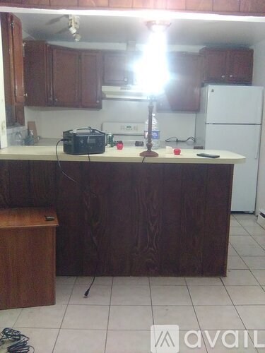 A kitchen with wooden cabinets and a white fridge.