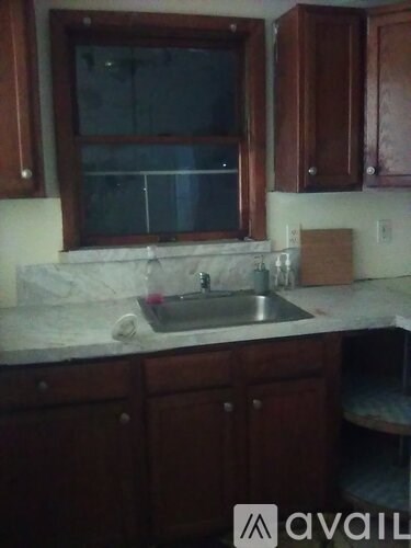 A kitchen with brown cabinets and a marble countertop.