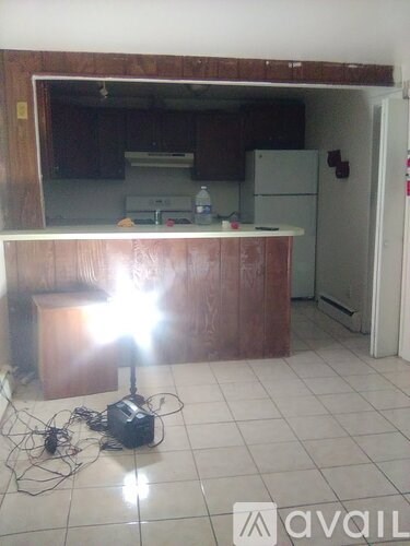 A kitchen with a brown counter and a white fridge.