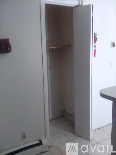 A white door is open to a small empty room.