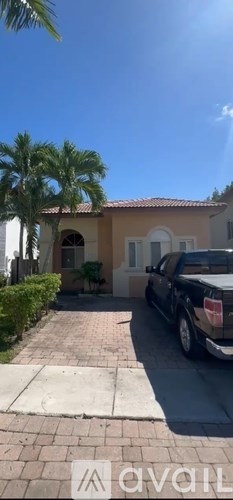 A house with a black truck parked in front.