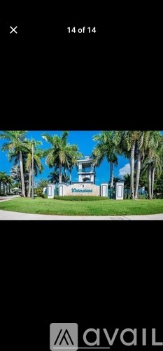 A building with a sign that says "Welcome" in front of palm trees.