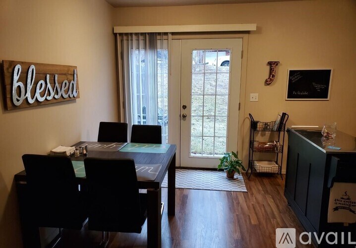 A dining room with a table and chairs and a sign that says "blessed".