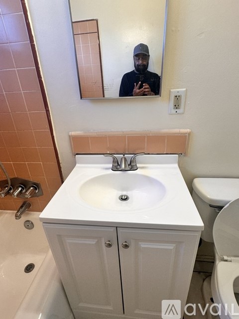 A man is taking a selfie in a bathroom mirror.