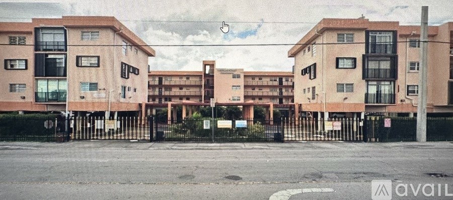 A row of apartment buildings with a gated entrance in front.