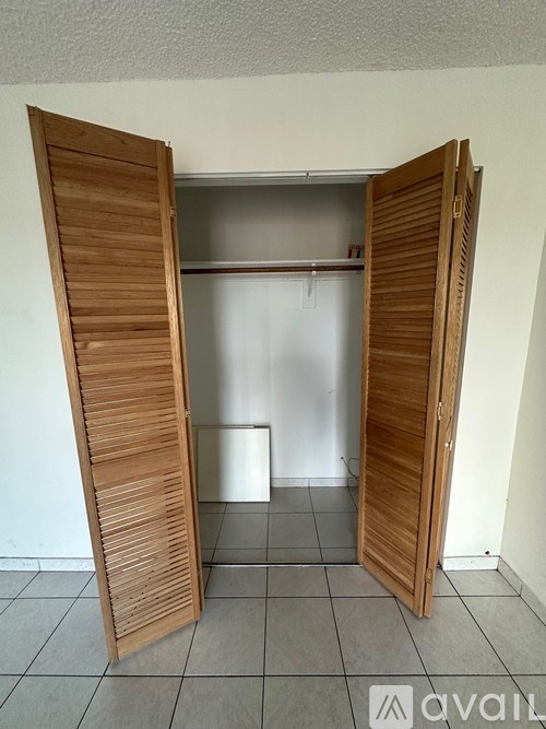 A room with a white wall and a wooden door.
