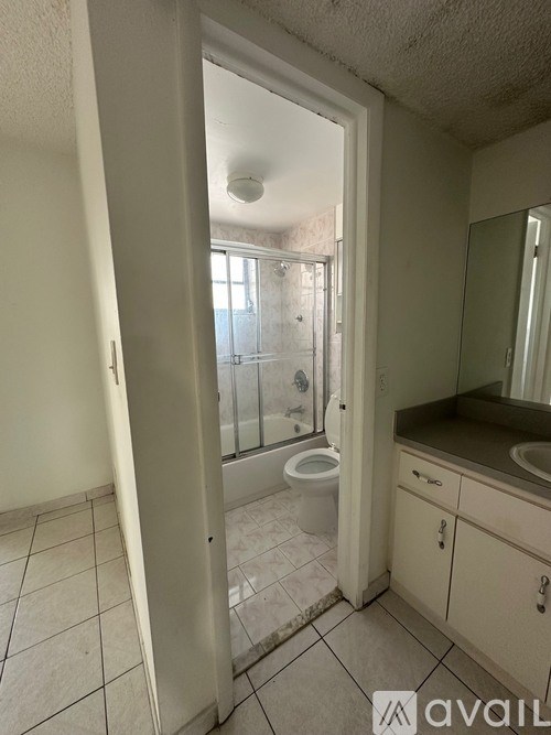 A bathroom with a toilet, sink, and mirror.