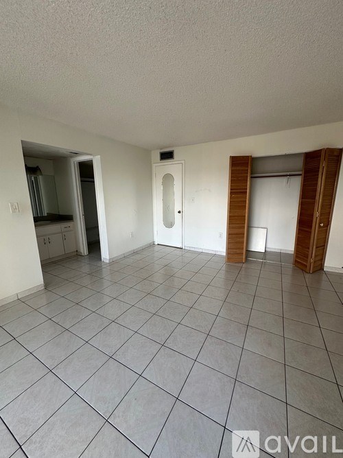 A room with a tiled floor and a doorway leading to another room.