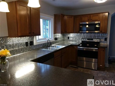A kitchen with wooden cabinets and a black countertop.