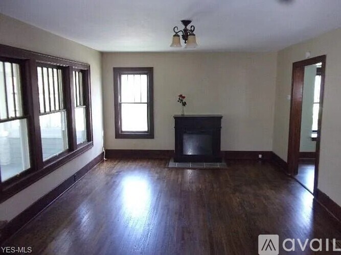 A living room with a fireplace and a vase of flowers.