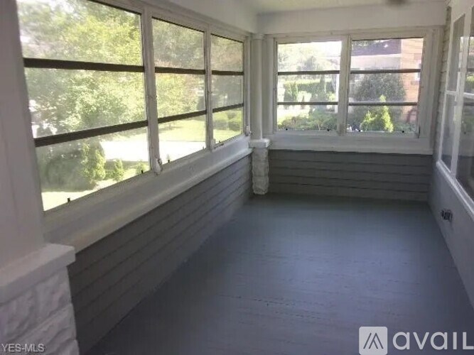 A sunny room with a large window and a fireplace.