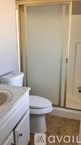 A bathroom with a toilet, sink and shower.