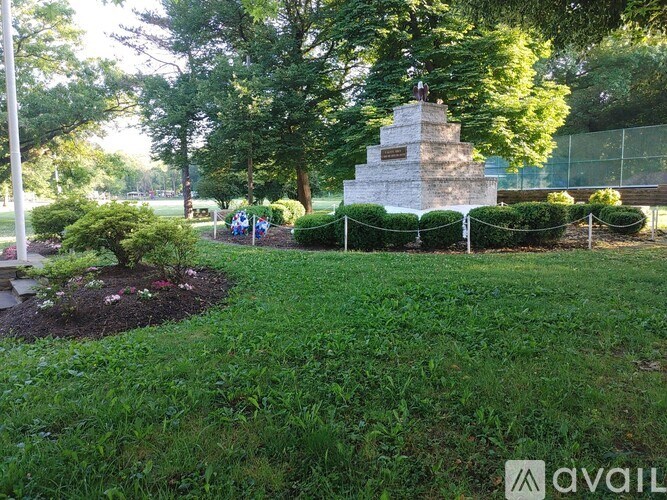 A monument in a park surrounded by a fence and greenery.